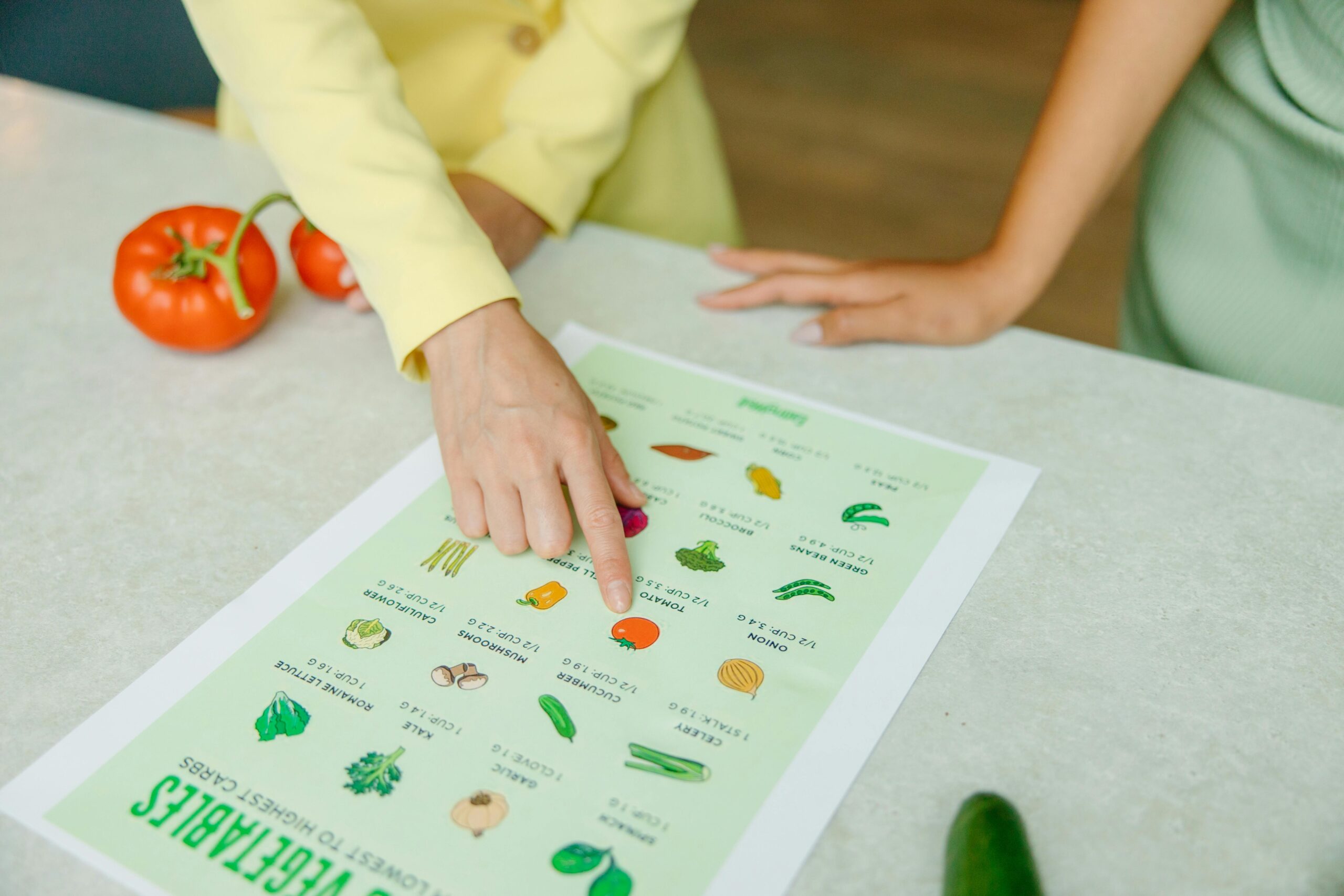 Mano señalando alimentos en tabla nutricional durante una consulta de nutrición clínica